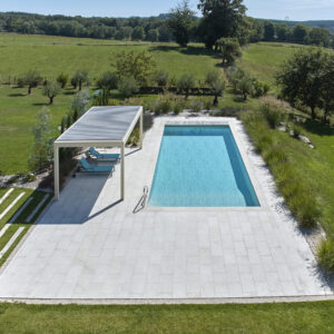 Piscine Classique 13 x 4,80 m avec escalier d'angle banquette, margelles et plages en pierre naturelle