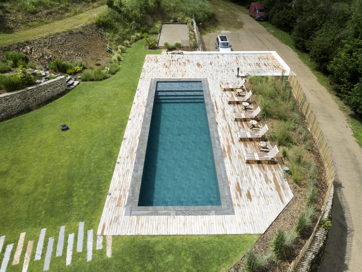 Rénovation d'un couloir de nage aux dimensions 14,00 x 4,00 m relevé de 0,60 m et décalé de 2,00 m avec un terrasse en bois et des margelles gris clair