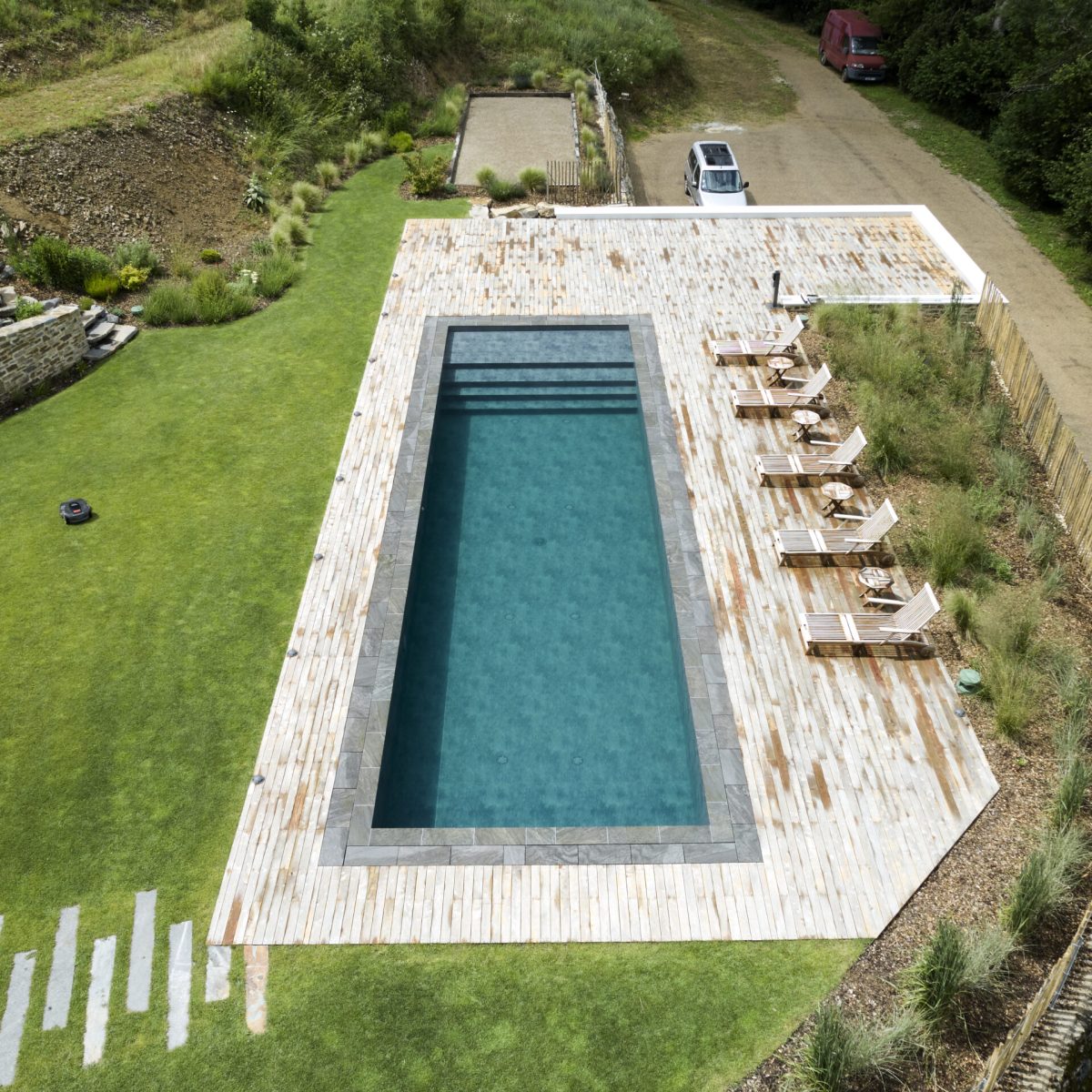 Rénovation d'un couloir de nage aux dimensions 14,00 x 4,00 m relevé de 0,60 m et décalé de 2,00 m avec un terrasse en bois et des margelles gris clair