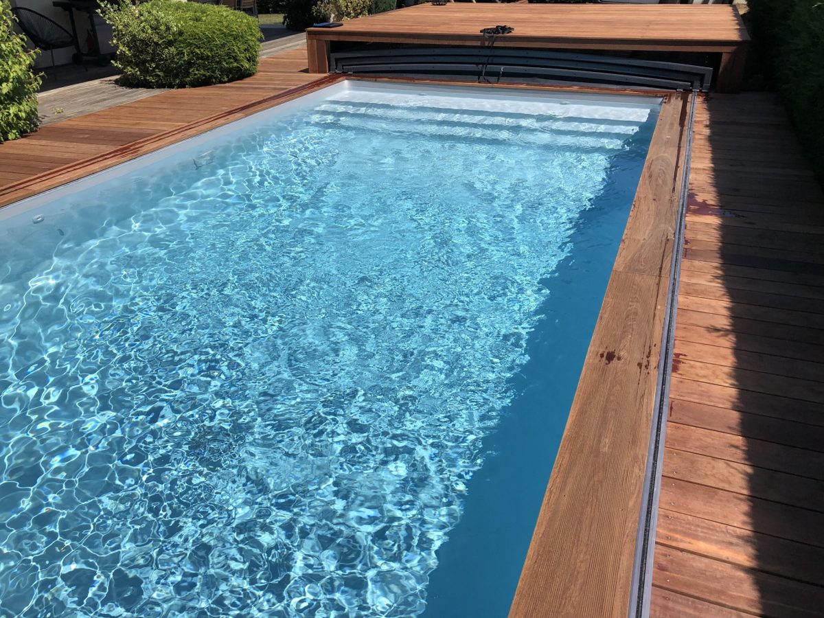 Piscine rectangulaire avec abri plat et rangement sous la terrasse, plage et lagon grès cérame